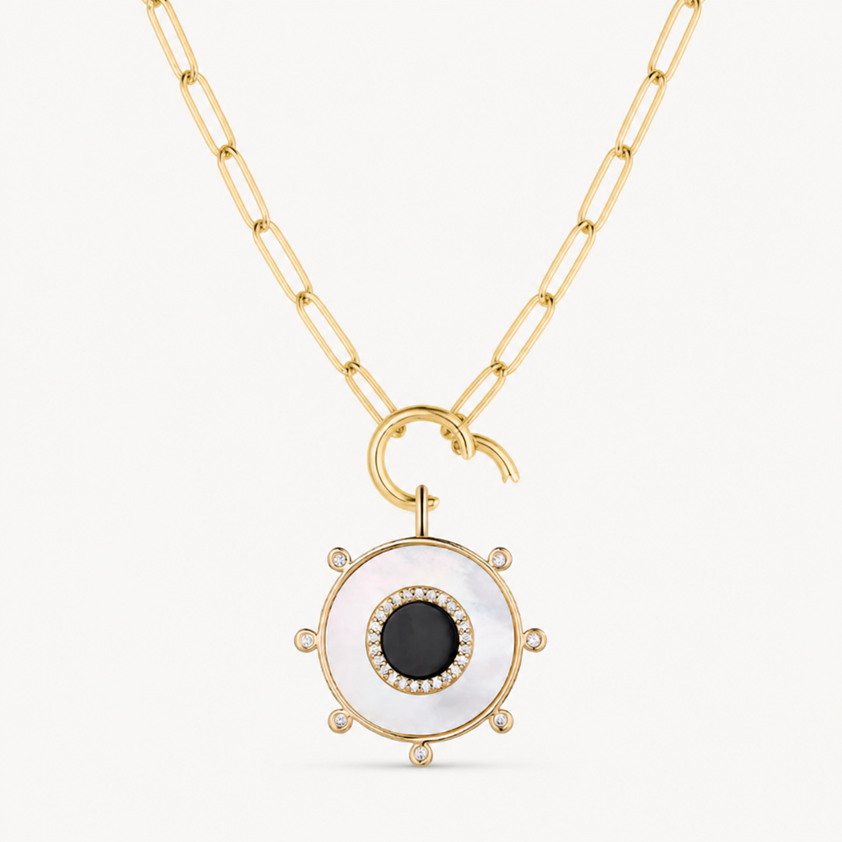 mother of pearl & black onyx round charm shown on a gold paperclip charm necklace