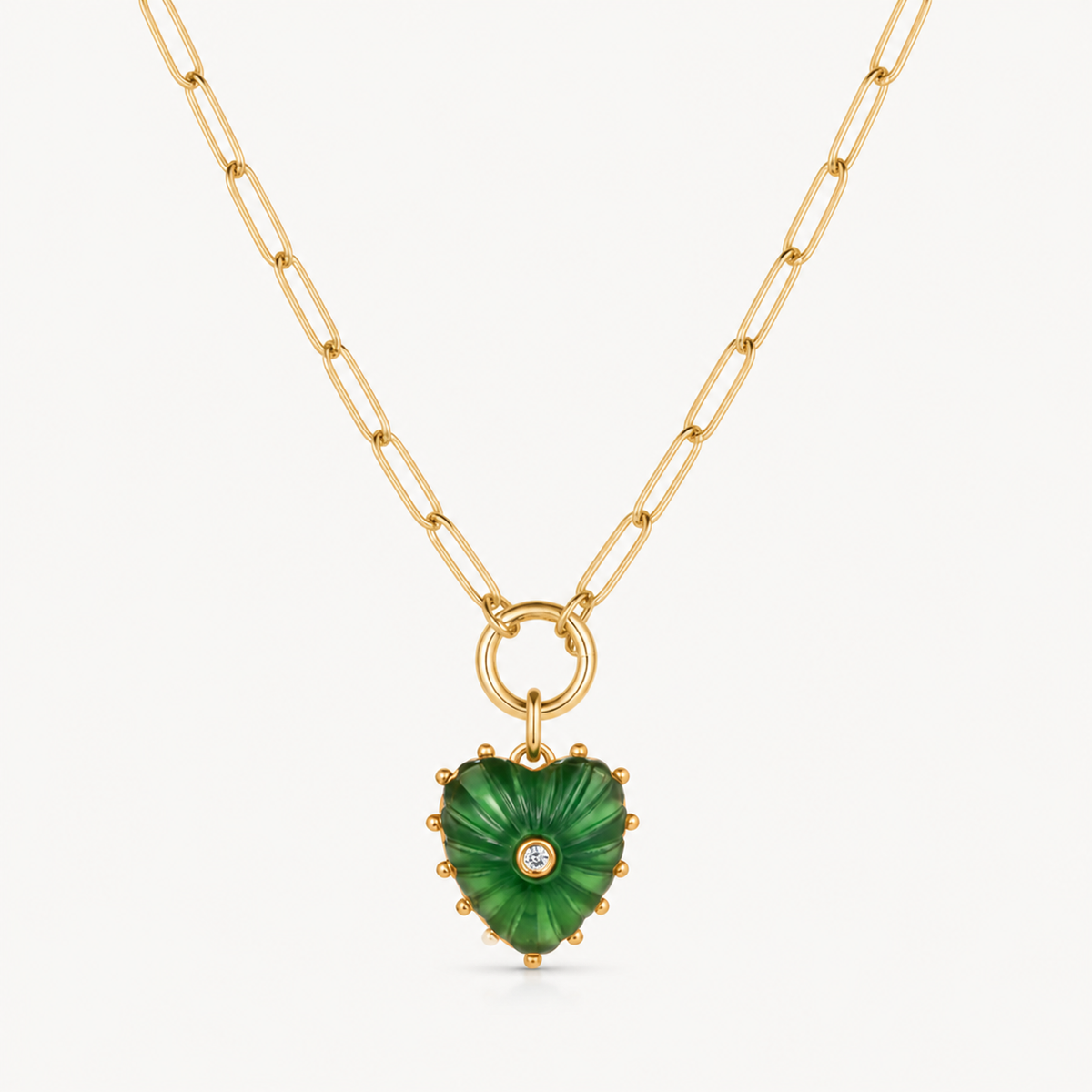 small green jade carved heart charm shown on a gold paperclip charm necklace