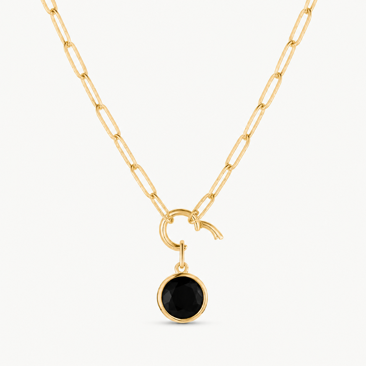 black cubic zirconia round charm shown on a gold paperclip charm necklace