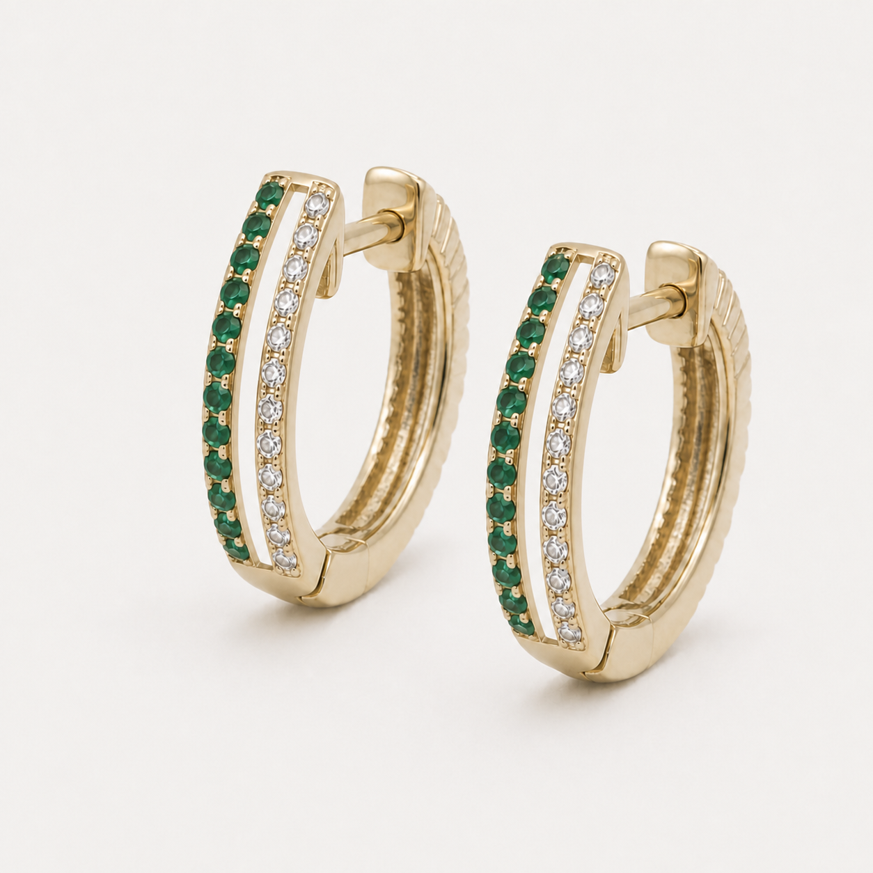 14K yellow gold huggie earrings with separate emerald and diamond rails and an open slot between them