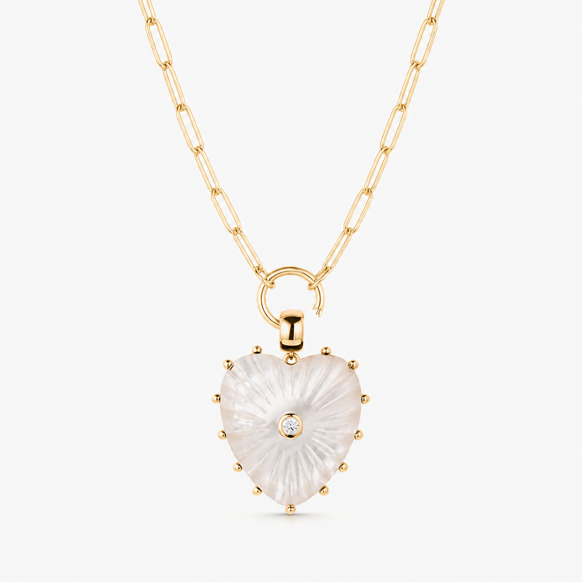 large mother of pearl carved heart charm shown on a gold paperclip charm necklace