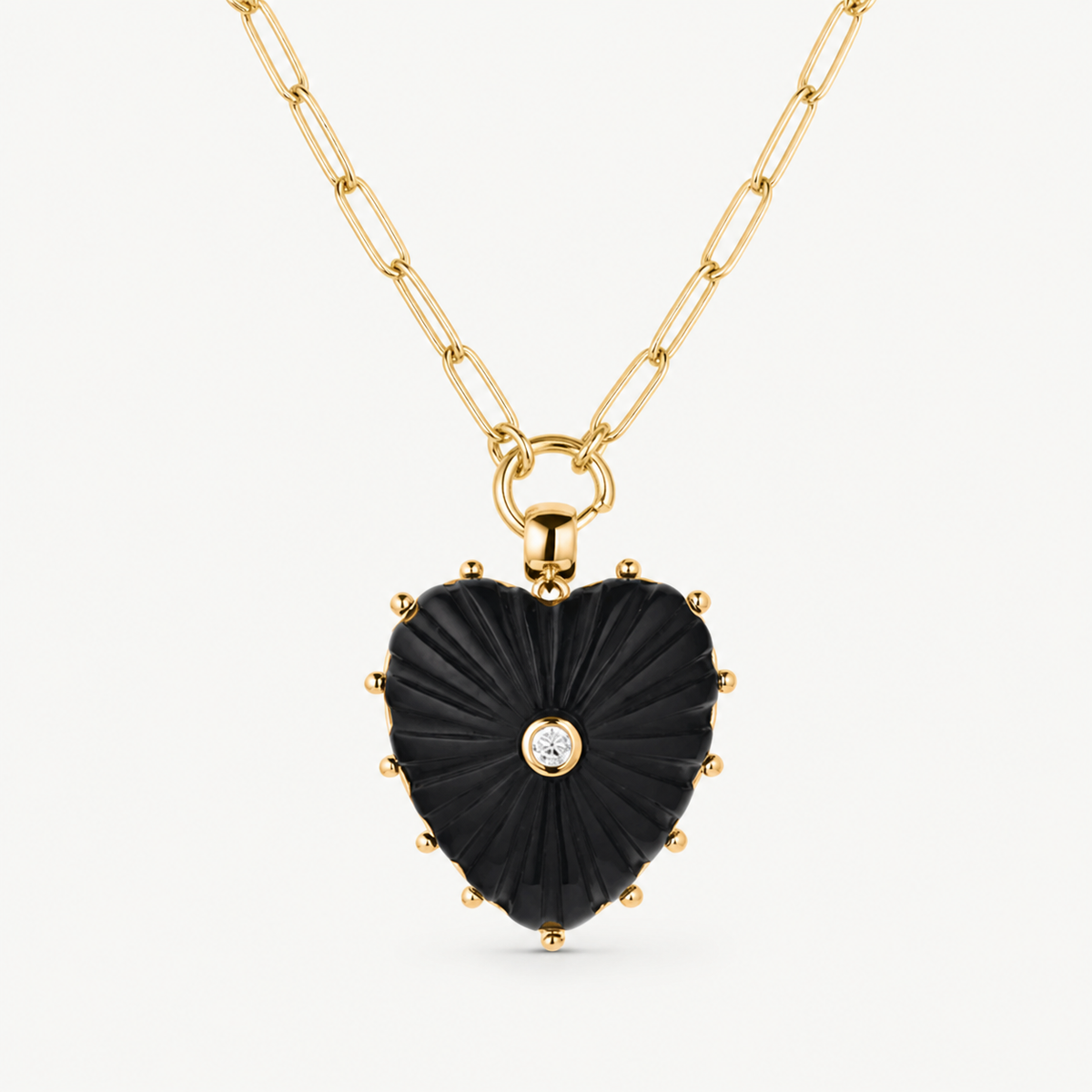 large onyx carved heart charm shown on a gold paperclip charm necklace