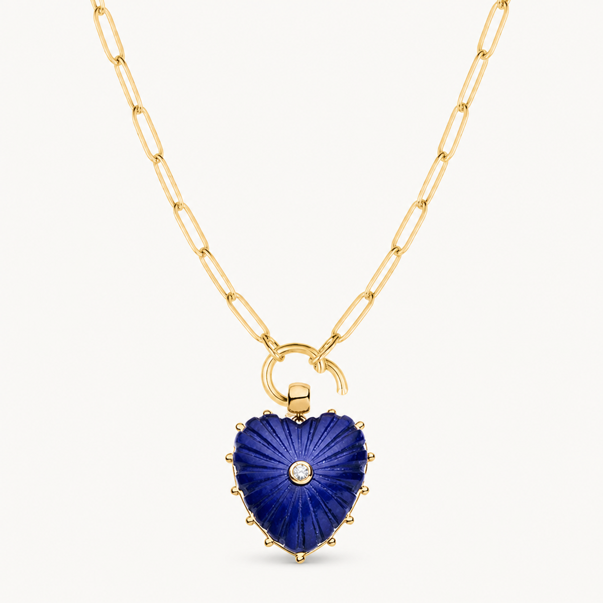 carved heart charm shown on a gold paperclip charm necklace