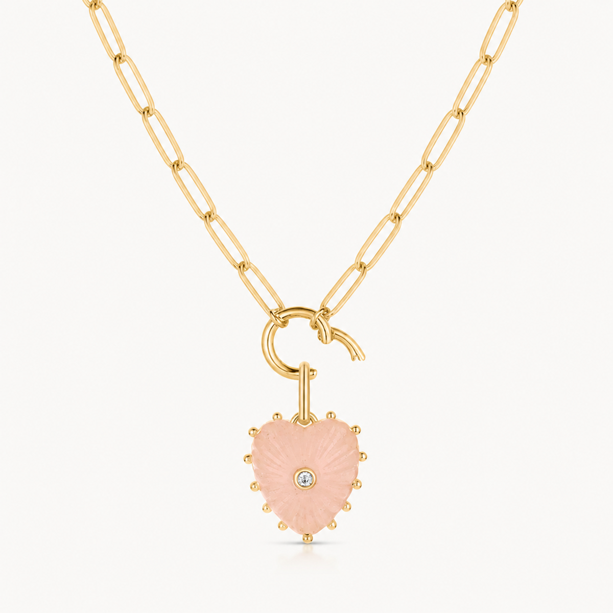 small pink jade carved heart charm shown on a gold paperclip charm necklace
